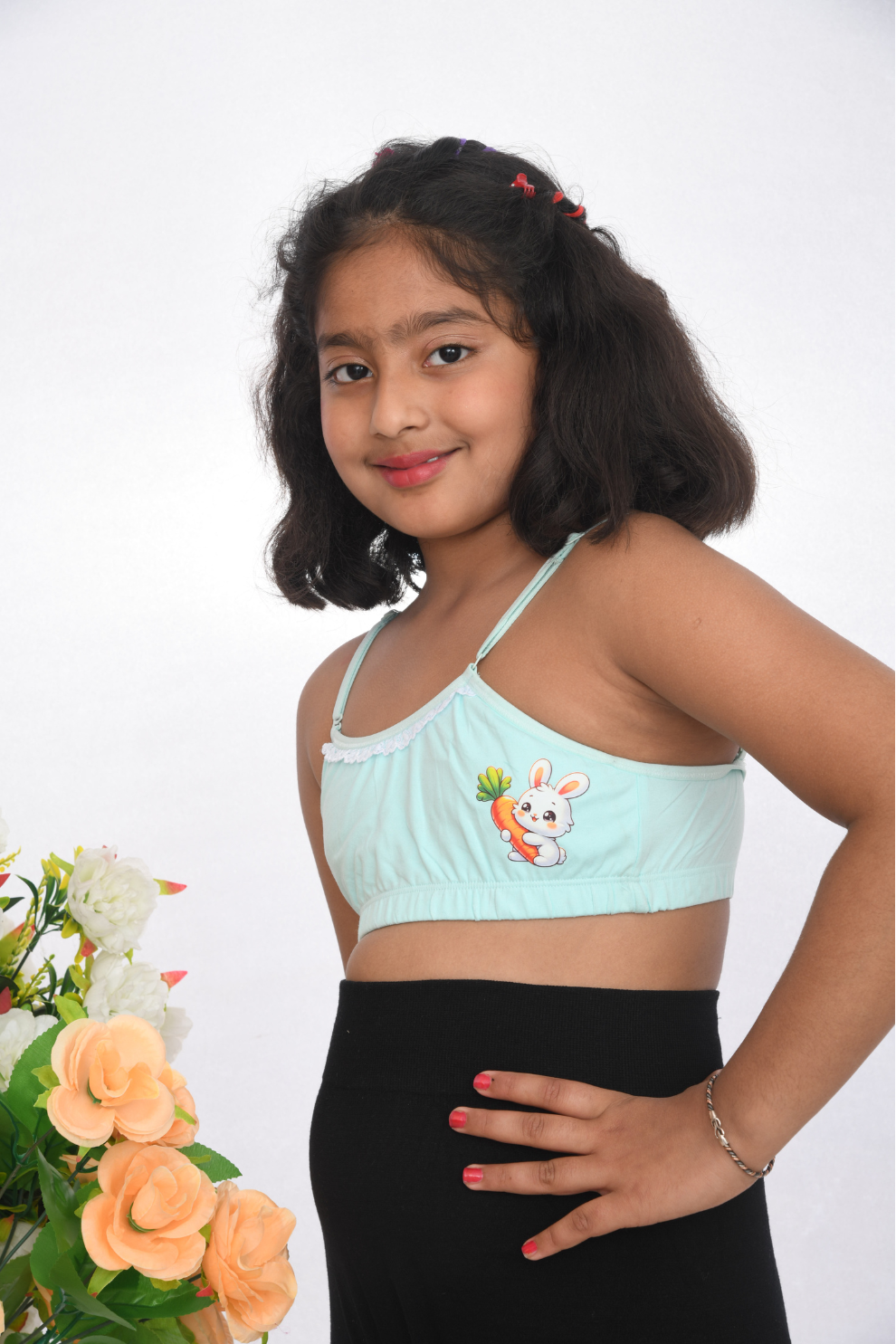 Teenage girl wearing a sea green training bra with lace detailing, side view, adjustable straps.